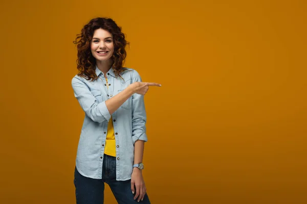 Alegre Encaracolado Ruiva Mulher Apontando Com Dedo Laranja — Fotografia de Stock