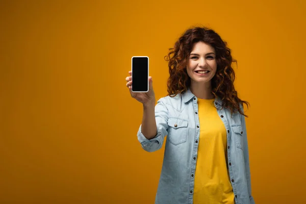 Fröhliche Rothaarige Frau Hält Smartphone Mit Leerem Bildschirm Auf Orange — Stockfoto