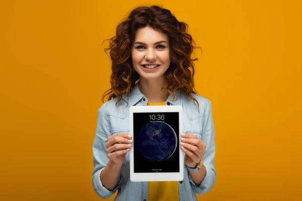 Veselou Rudou Ženu Držící Digitální Tablet Zámkem Zatímco Stojí Oranžovém — Stock fotografie