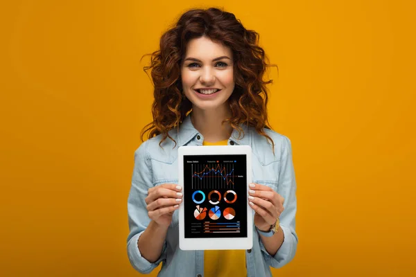 Boldog Vöröshajú Aki Digitális Tabletta Grafikonok Görbék Képernyőn Állva Narancssárga — Stock Fotó