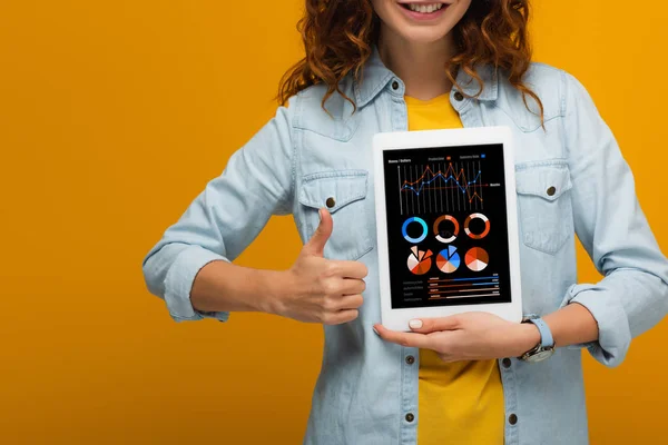 화면에 차트와 그래프와 디지털 태블릿을 오렌지에 손가락을 보여주는 쾌활한 소녀의 — 스톡 사진