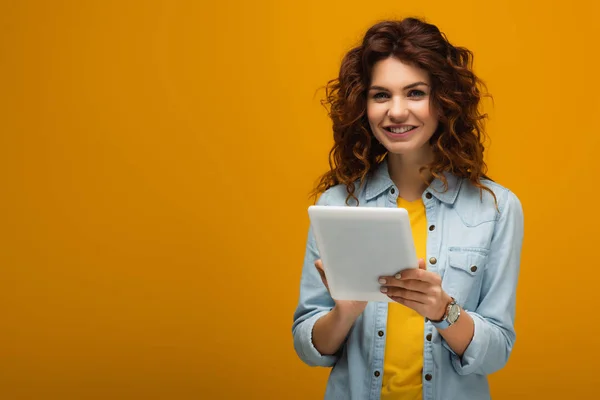 Cheerful Curly Redhead Girl Looking Camera Holding Digital Tablet Orange — Stock Photo, Image