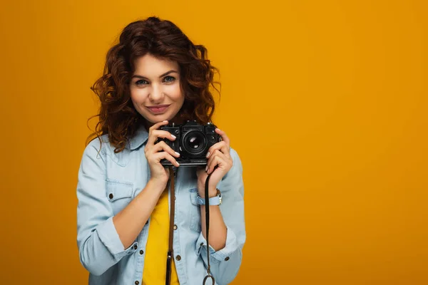 Curly Redhead Photographer Holding Digital Camera Isolated Orange — Stock Photo, Image