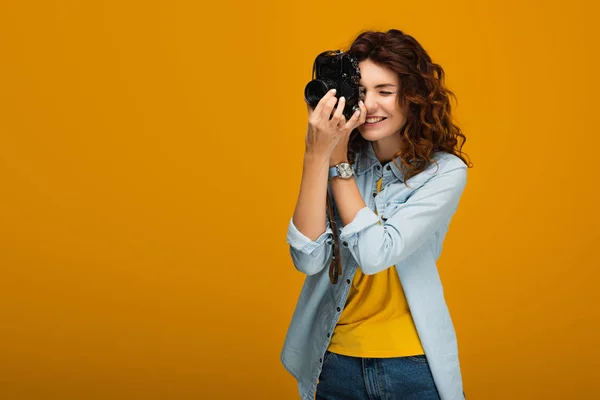 Fotógrafo Pelirroja Feliz Tomando Fotos Mientras Sostiene Cámara Digital Naranja — Foto de Stock