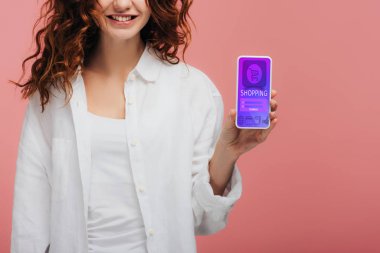 pembe ekranda alışveriş uygulaması ile akıllı telefon tutan neşeli kız kırpılmış görünümü