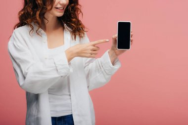 pembe boş ekran ile akıllı telefonda parmak ile işaret neşeli kız kırpılmış görünümü