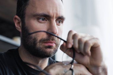 gözlük tutan ve uzağa bakan dalgın sakallı adam seçici odak