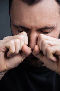 kapalı gözleri ile elleri ile gözyaşlarını silerek depresif ağlayan adam