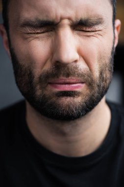 kapalı gözlerle ağlayan yakışıklı, depresif traşsız adam portresi