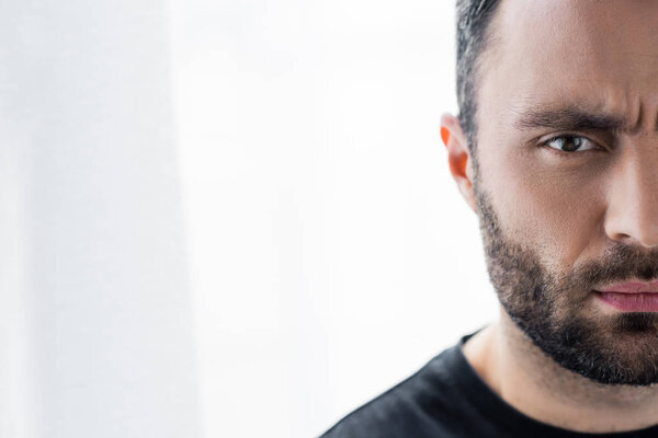 частичный взгляд вдумчивого, красивого бородатого мужчину, смотрящего в камеру
