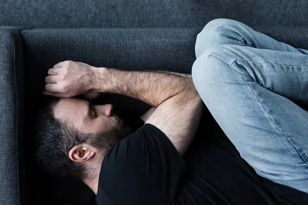 Vista Superior Homem Deprimido Barbudo Sofrendo Enquanto Deitado Sofá Com — Fotografia de Stock