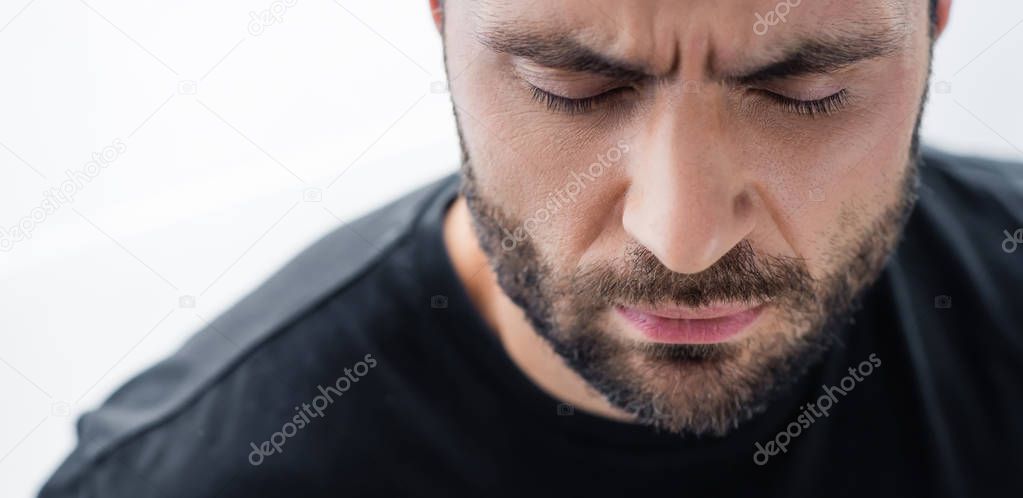 panoramic shot of depressed bearded man with closed eyes