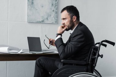 işyerinde tekerlekli sandalyede oturan hayal kırıklığına engelli işadamı 