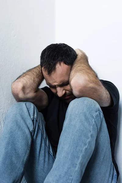 Adulto Frustrado Homem Sofrendo Enquanto Sentado Canto Segurando Mão Cabeça — Fotografia de Stock