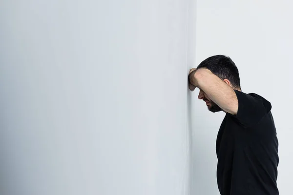 Ενήλικος Αναστατωμένος Άνθρωπος Μαύρο Μπλουζάκι Που Στέκεται Από Λευκό Τοίχο — Φωτογραφία Αρχείου