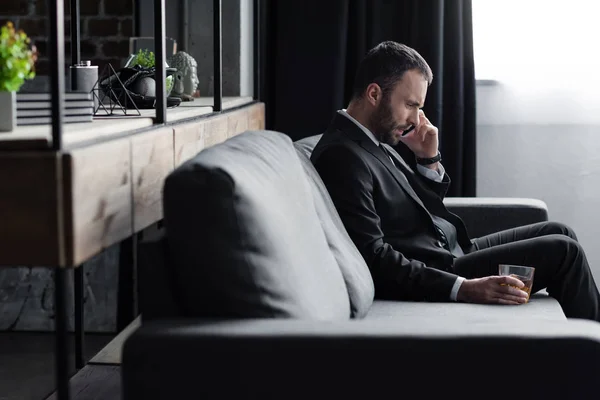 Λυπημένος Επιχειρηματίας Κοστούμι Κάθεται Στον Καναπέ Smartphone Και Ποτήρι Ουίσκι — Φωτογραφία Αρχείου