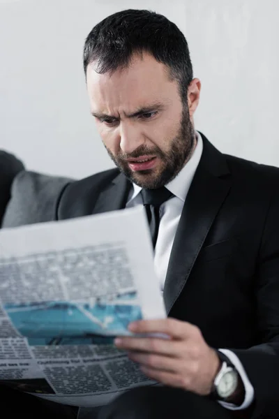 ショックを受けたあごひげのビジネスマンの選択的焦点新聞を読む — ストック写真
