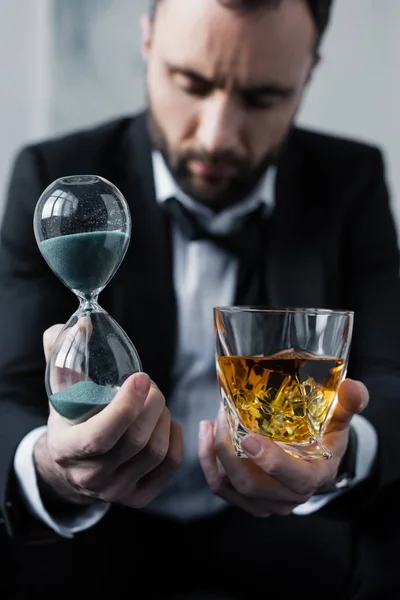 Selektiver Fokus Des Verärgerten Geschäftsmannes Mit Sanduhr Und Glas Whiskey — Stockfoto