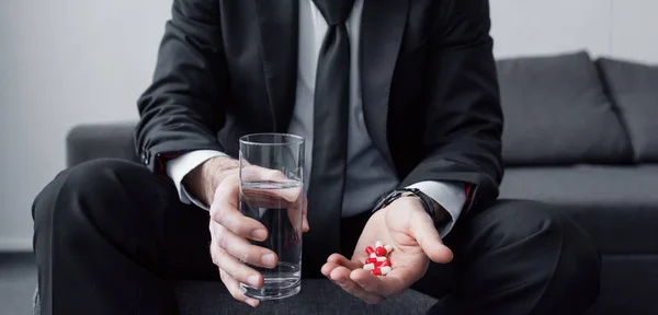 Vista Parcial Del Hombre Sentado Sosteniendo Vaso Agua Puñado Pastillas — Foto de Stock