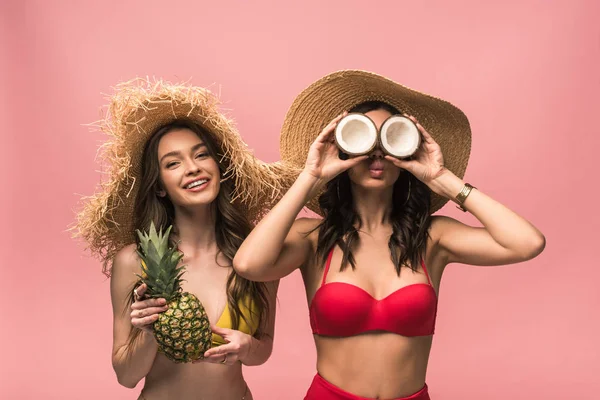 Two Smiling Girls Straw Hats Holding Coconuts Pineapple Isolated Pink — Stock Photo, Image