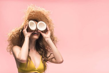 pembe izole hindistan cevizi tutan hasır şapka neşeli kız