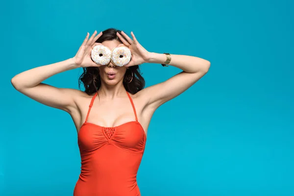 Überrascht Mädchen Badeanzug Hält Donuts Isoliert Auf Blau — Stockfoto