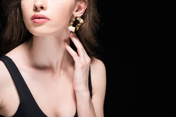 частичный вид девушки нежно касаясь шеи изолированы на черном
