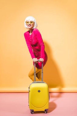 sarı üzerinde bavul ile poz moda çekici kız 