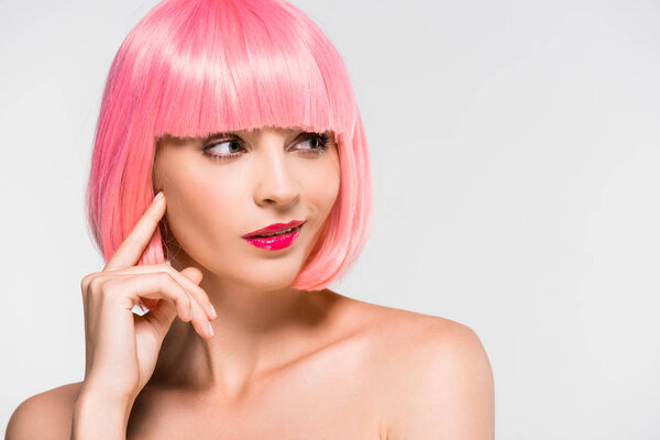 pensive naked girl in pink wig isolated on grey