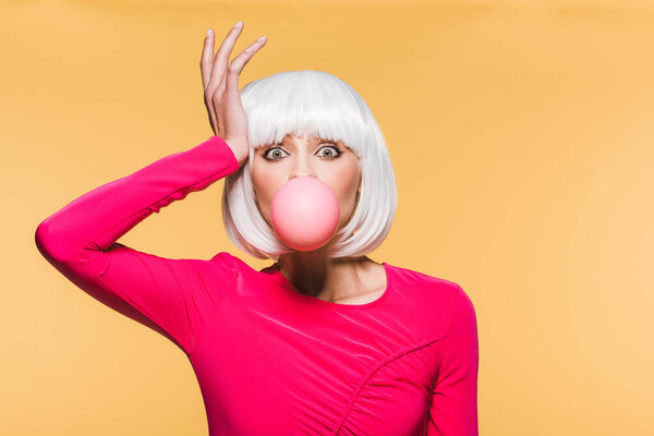 stylish girl in white wig with pink bubble gum, isolated on yellow