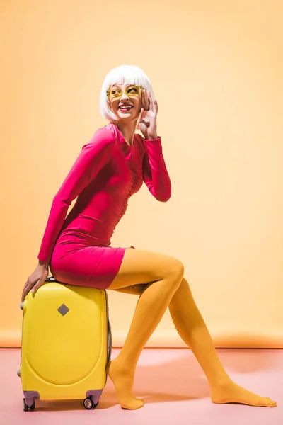 黄色のスーツケースでポーズファッショナブルな笑顔の女の子 — ストック写真