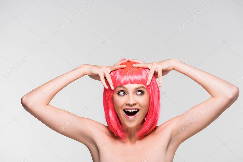 excited nude young woman in pink wig isolated on grey