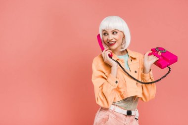 beyaz peruk güzel genç kadın retro telefon konuşurken, pembe izole 