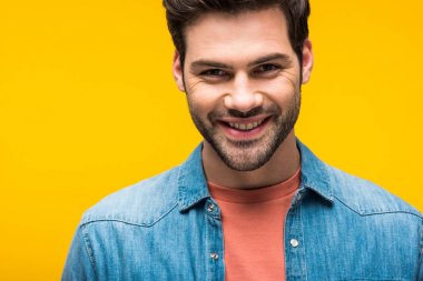 gülümseyen iyi görünümlü adam sarı üzerinde izole kamera bakıyor