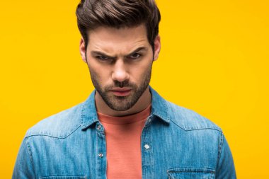 yakışıklı agresif adam sarı üzerinde izole kamera bakıyor