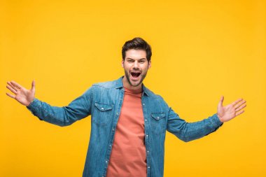 Açık avuç içi sarı üzerinde izole yakışıklı heyecanlı adam işaret