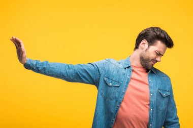 memnun yakışıklı adam sarı izole dur işareti yapıyor