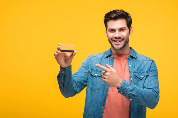 Homem Bonito Feliz Apontando Com Dedo Cartão Crédito Isolado Amarelo — Fotografia de Stock