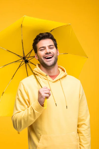 Guapo Hombre Sosteniendo Paraguas Riendo Aislado Amarillo —  Fotos de Stock