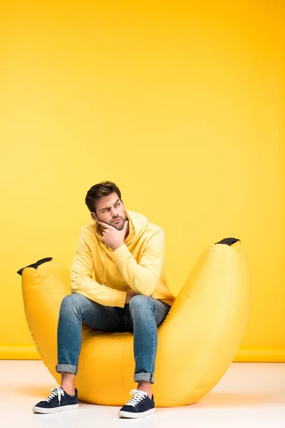 Στοχαστικός Άνθρωπος Στην Καρέκλα Τσάντα Φασολιών Αγγίζοντας Πηγούνι Στο Κίτρινο — Φωτογραφία Αρχείου