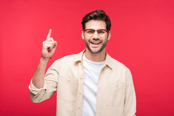Улыбающийся красивый мужчина, указывающий пальцем на розовый
