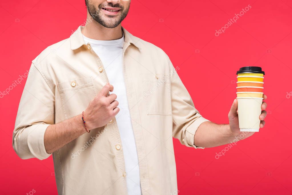 cropped view of man holding paper cups with coffee to go Isolated On pink