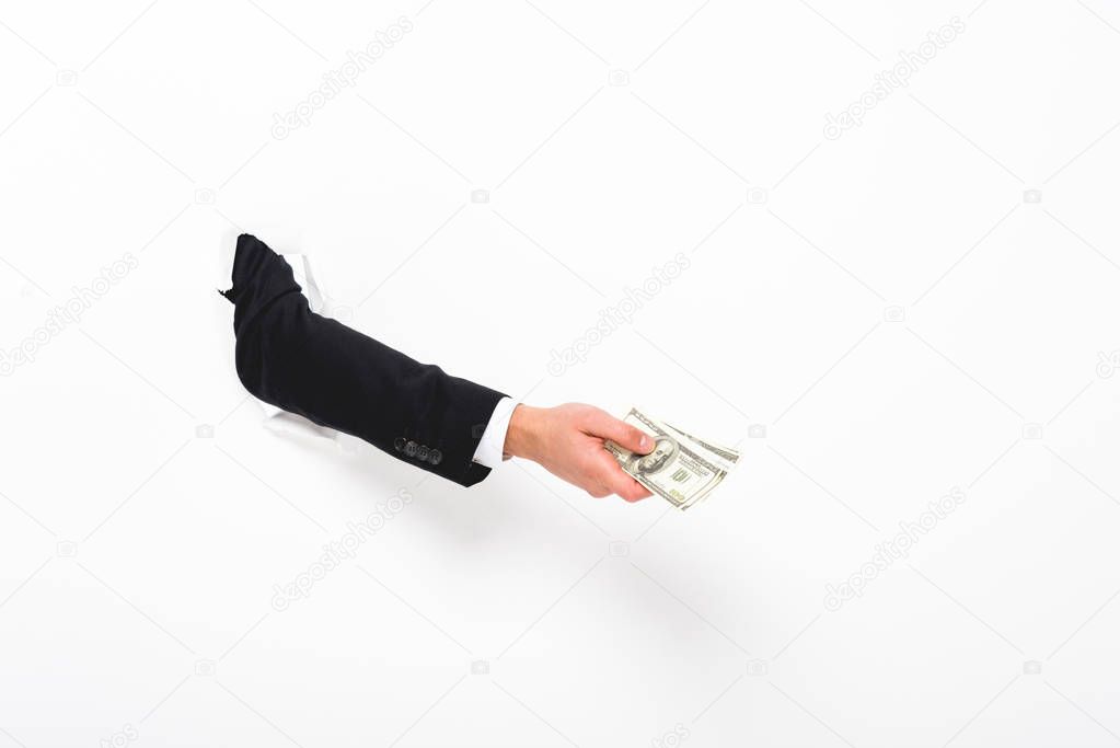 Cropped view of man holding money through hole in paper wall on white
