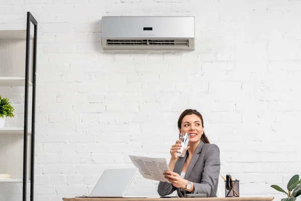 Vrolijke Zakenvrouw Drinkwater Terwijl Werkplek Zit Onder Airconditioner — Stockfoto