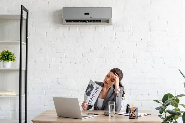 Aantrekkelijke Zakelijke Vrouw Zwaaiende Krant Terwijl Zittend Werkplek Onder Airconditioner — Stockfoto