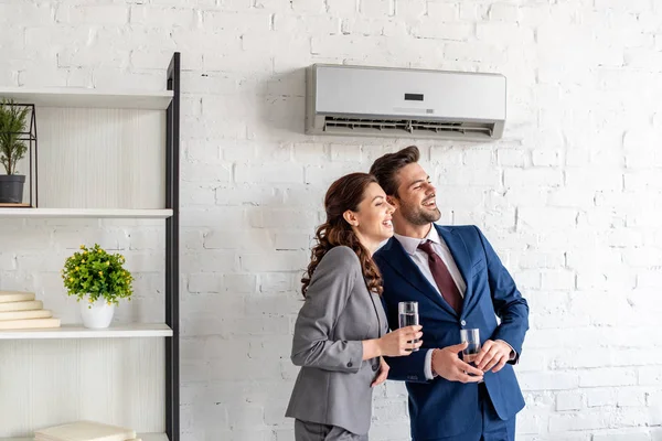 Smiling Businesspeople Holding Glasses Water While Standing Air Conditioner Office — Stock Photo, Image