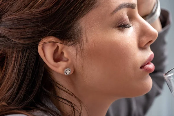 profile of beautiful woman suffering from heat with closed eyes on grey