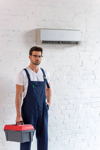 Seriöser Reparateur Overalls Mit Werkzeugkiste Und Blick Die Kamera Während — Stockfoto