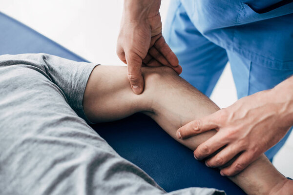 частичный взгляд мануального терапевта, массирующего руку пациента в больнице
