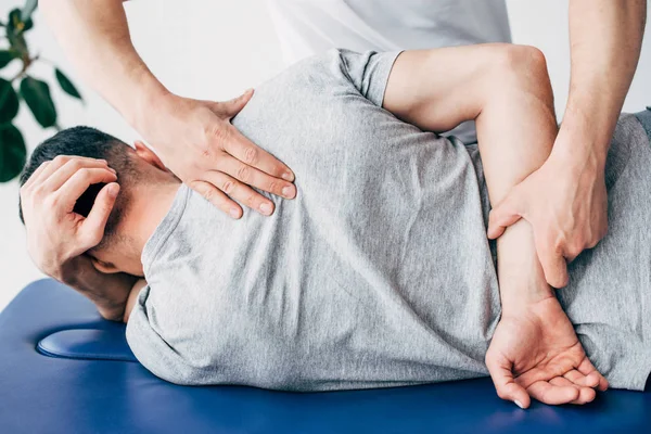 Rückenansicht Von Chiropraktiker Massiert Rücken Eines Auf Massagetisch Liegenden Mannes — Stockfoto